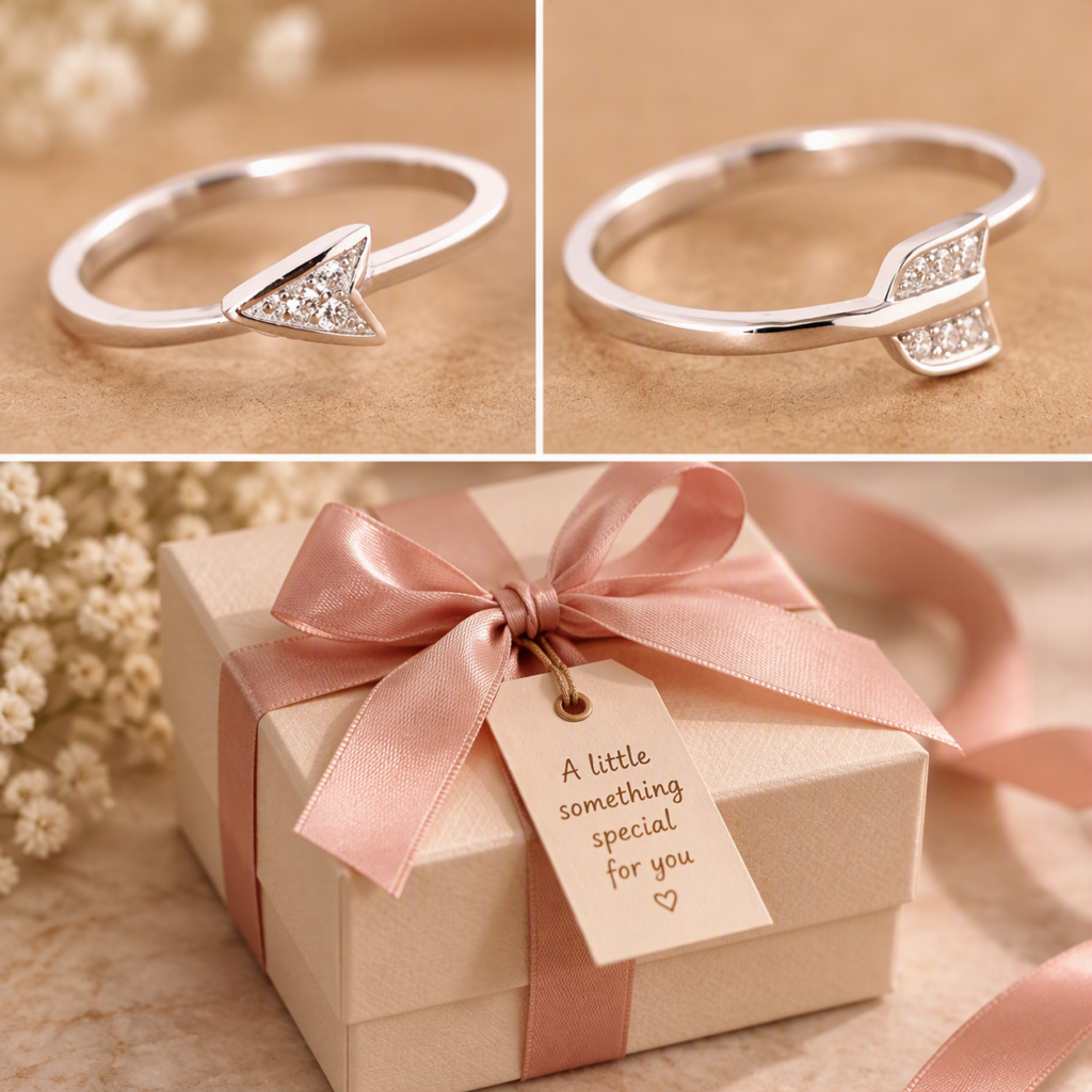 Silver arrow ring next to a gift box with a pink ribbon